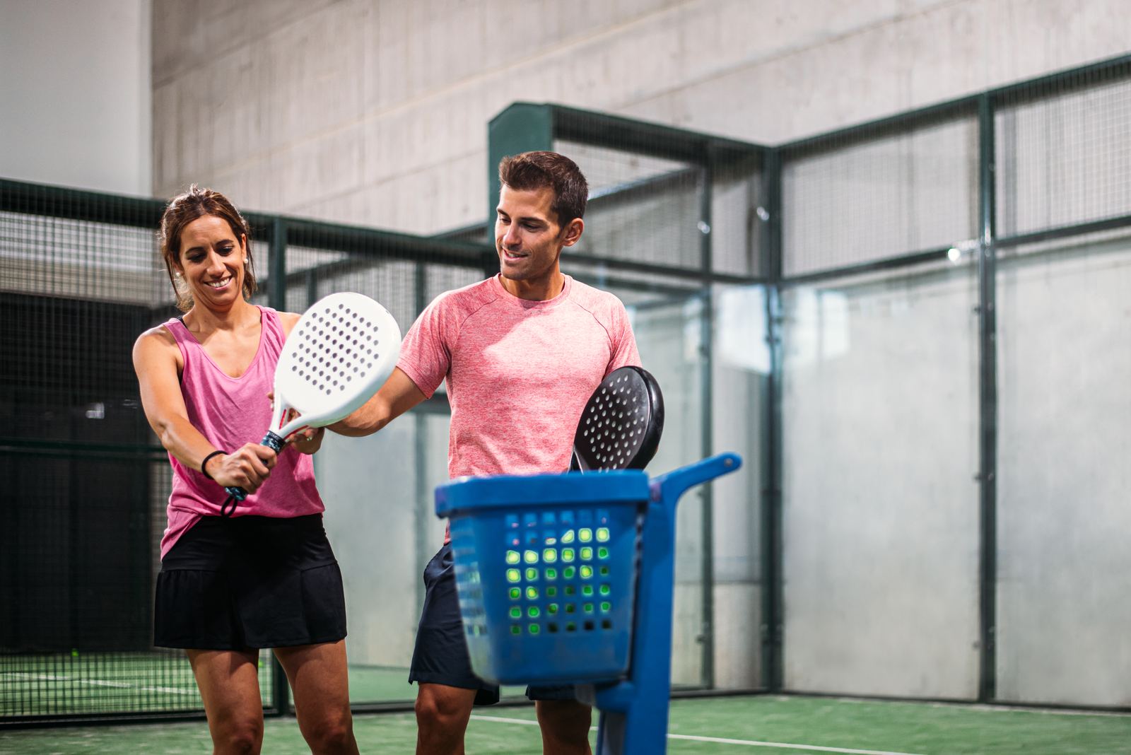 Padel coach teaching a beginner on court